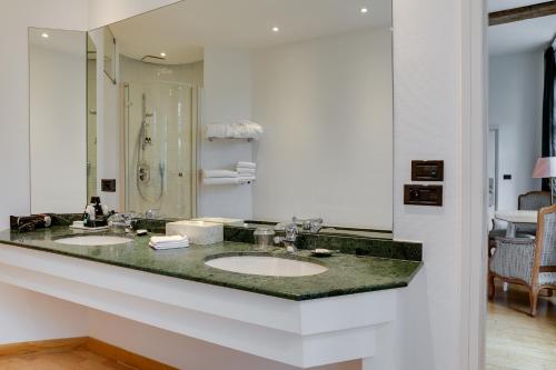 a bathroom with two sinks and a large mirror at Hotel De Witte Lelie -Small Luxury Hotels of the World in Antwerp