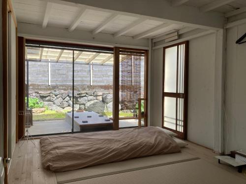 1 dormitorio con cama y ventana grande en パライソ梅田, en Ise