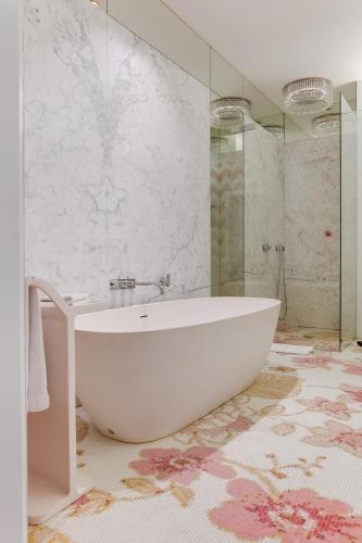 a bathroom with a white tub and a shower at Hotel De Witte Lelie -Small Luxury Hotels of the World in Antwerp