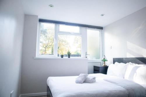 a white bedroom with a large bed with a window at Immaculate 4-Bed House in Southampton in Southampton
