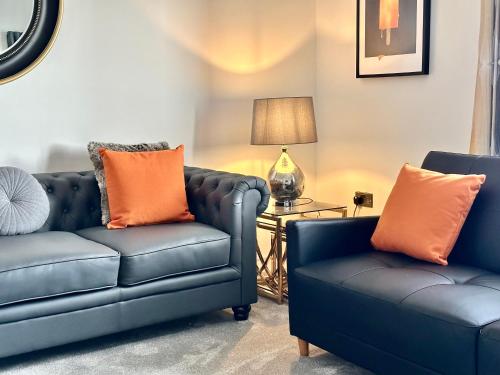 a living room with two blue couches and a lamp at South Beach Villa in Bridlington