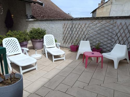 grupa krzeseł i stół na patio w obiekcie HOTEL DE FRANCE w mieście Tour-du-Pin