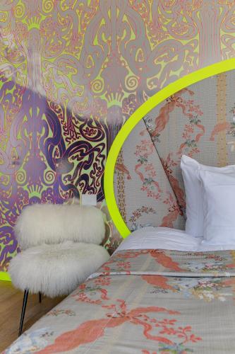 a bedroom with a bed and a colorful wall at Hotel De Witte Lelie -Small Luxury Hotels of the World in Antwerp