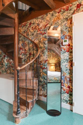 a spiral staircase in a room with a mural at Hotel De Witte Lelie -Small Luxury Hotels of the World in Antwerp