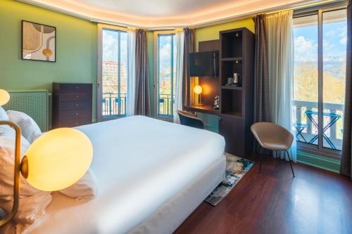 a hotel room with a bed and a large window at Le Splendid Hotel Lac D'Annecy - Handwritten Collection in Annecy