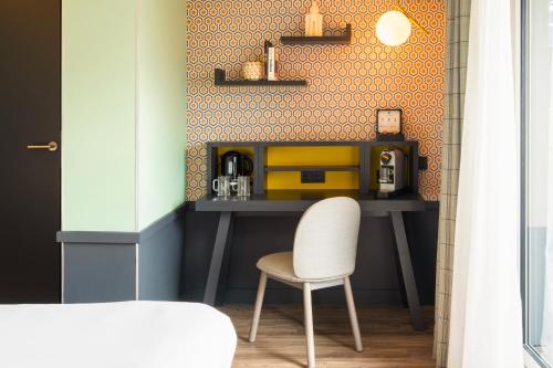 a room with a desk with a chair and a coffee maker at Le Splendid Hotel Lac D'Annecy - Handwritten Collection in Annecy