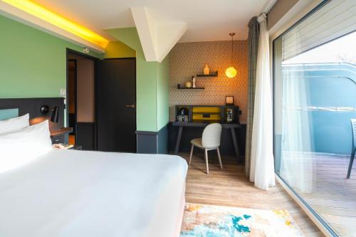 a bedroom with a bed and a desk with a chair at Le Splendid Hotel Lac D'Annecy - Handwritten Collection in Annecy
