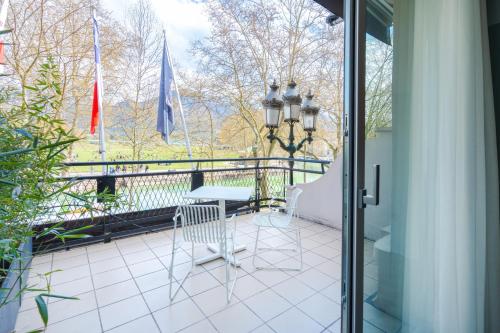 a balcony with a table and chairs and flags at Le Splendid Hotel Lac D'Annecy - Handwritten Collection in Annecy