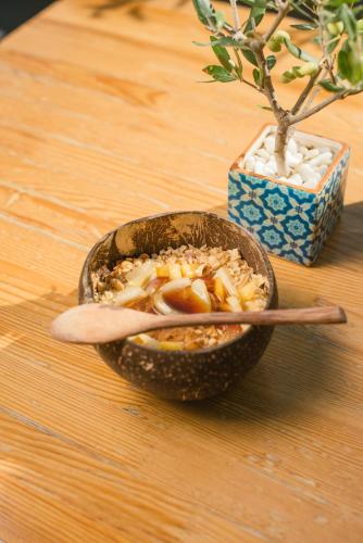 a bowl of food on a table with a spoon at Dominoes Corfu in Ýpsos