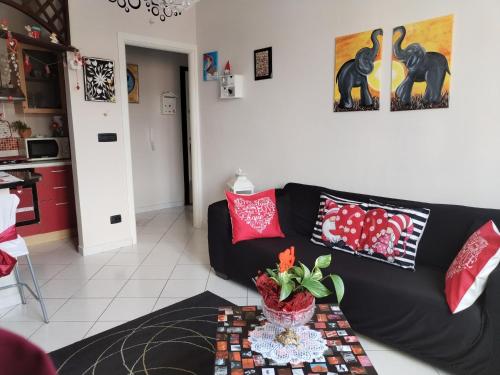 a living room with a black couch and a table at Nido delle meraviglie in Canelli