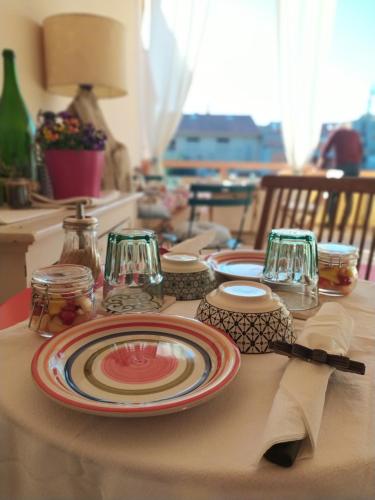 a table with plates and glasses on a table at Il Sentiero B&Bìo in SantʼAntìoco