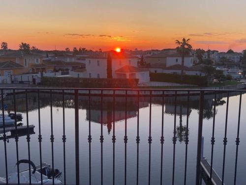 a sunset over a city with a body of water at Marina 120m²/8 pers/ terrasse 100m²/ appontement in Aigues-Mortes
