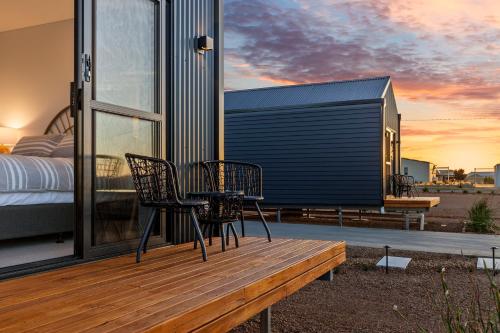 a room with a bed and chairs on a deck at Three Ponds Estate in Temora