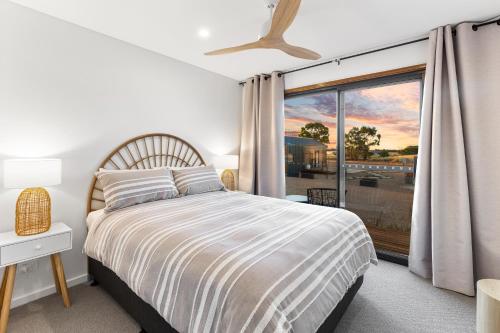 a bedroom with a bed and a large window at Three Ponds Estate in Temora