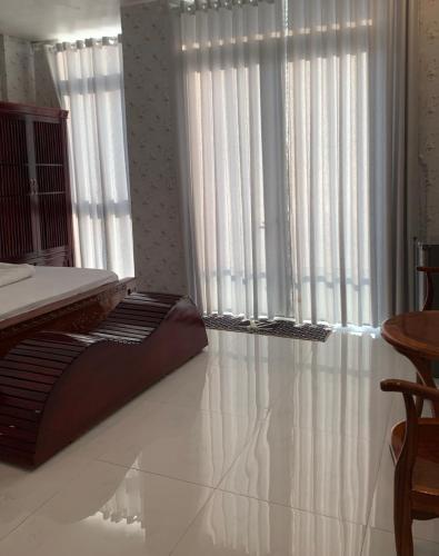 a room with white curtains and a bed in front of a window at MOTEL MINH ANH in Ấp Rạch Mẹo