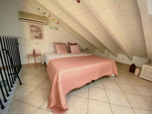 a bedroom with a bed with a pink blanket at VILLA GIOIA - Piscina nel Monferrato in Pecetto di Valenza