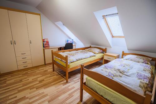 a bedroom with two beds and a staircase at Apartment Rimljanček in Leskovec pri Krškem