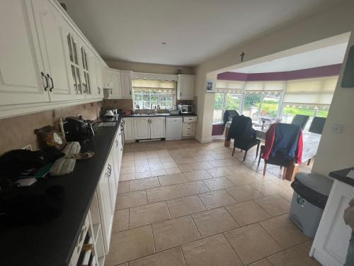 a kitchen with white cabinets and a tile floor at graiguenamanagh Homestay in Graiguenamanagh