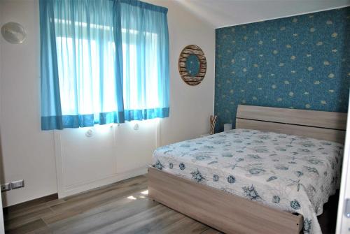 1 dormitorio con cama y ventana en CASA DINKY Attico con terrazza vista mare, en Formia