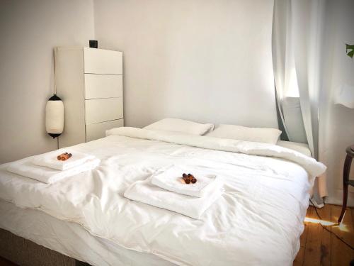 a white bed with two towels on top of it at Beach House Orłowo in Gdynia