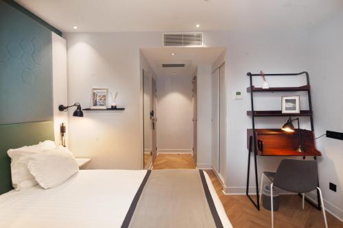 een slaapkamer met een bed, een bureau en een stoel bij Hôtel Vendome Saint-Germain in Parijs