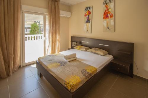 a bedroom with a large bed with a large window at Indigo luxury apartments in Olympiaki Akti