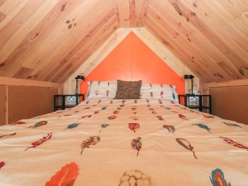 een groot bed in een kamer met een houten plafond bij North Light Studio in Carinish