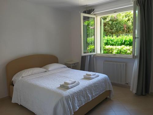 a bedroom with a bed with two towels on it at Appartamento a Forte dei Marmi con giardino e 2 posti auto in Querceta