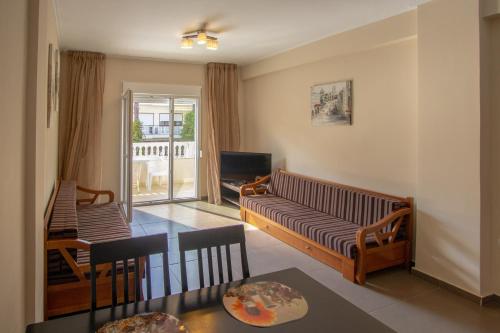 a living room with a couch and a table at Indigo luxury apartments in Olympiaki Akti