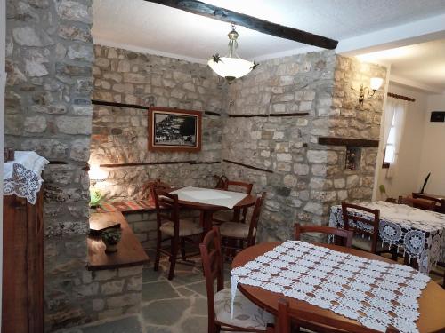uma sala de jantar com uma mesa e uma parede de pedra em Guest House J.Prifti em Berat