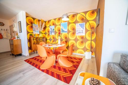 un salon avec une table et des chaises dans l'établissement LE SEVENTIE'S 3 Terrasse-Netflix-Wifi-Parking-Mer-TOP PROS SERVICESConciergerie, à La Grande Motte