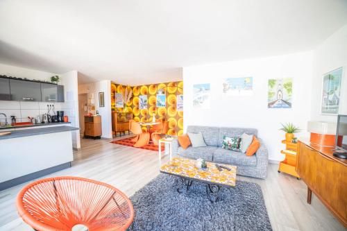 a living room with a couch and a table at LE SEVENTIE'S 3 Terrasse-Netflix-Wifi-Parking-Mer-TOP PROS SERVICESConciergerie in La Grande Motte