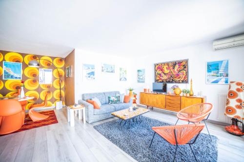 - un salon avec un canapé bleu et des fauteuils orange dans l'établissement LE SEVENTIE'S 3 Terrasse-Netflix-Wifi-Parking-Mer-TOP PROS SERVICESConciergerie, à La Grande Motte
