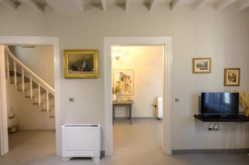 a room with a hallway with a television and a staircase at Elia downtown eco house in Mytilini