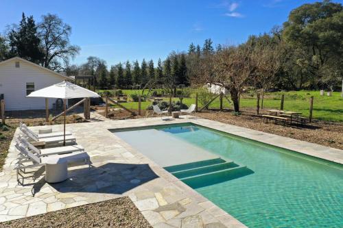 a swimming pool with a bench and an umbrella at Healdsburg Homestead A Wine Country Escape in Healdsburg