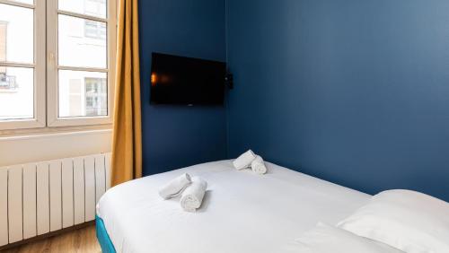 a blue room with a bed with towels on it at STUDIO STANDING BELLECOUR Centre in Lyon