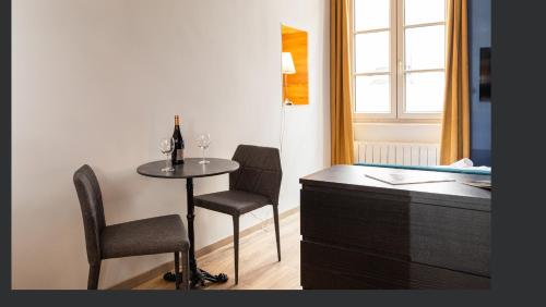 a room with a table and two chairs and a tub at STUDIO STANDING BELLECOUR Centre in Lyon