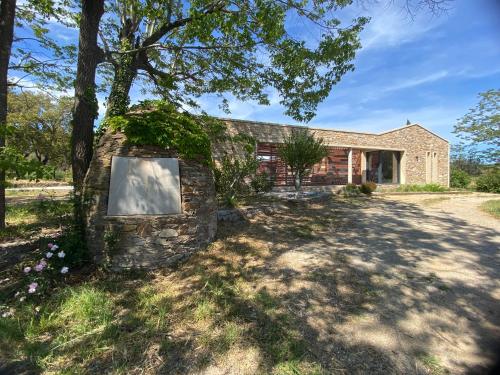 a stone house with a tree in front of it at Magnifique villa avec piscine au coeur des vignes in Cogolin