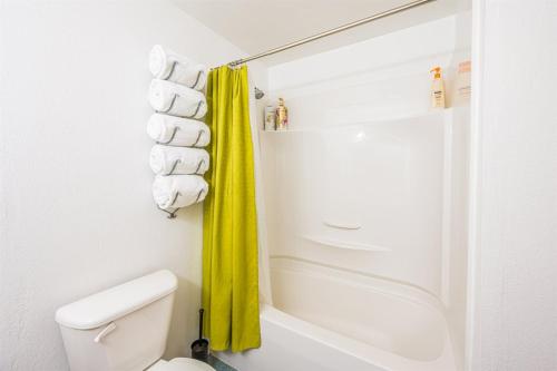 łazienka z toaletą i żółtą zasłoną prysznicową w obiekcie PA West Side Paradise w mieście Port Angeles