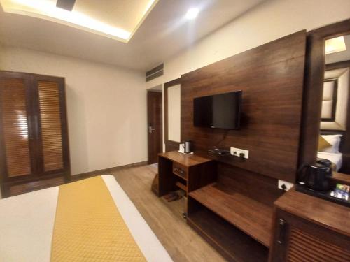 Habitación de hotel con cama y TV de pantalla plana. en HOTEL BLUE ORCHID - A 3 STAR HEAVEN IN Tricity, en Zirakpur