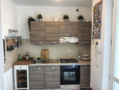 a kitchen with wooden cabinets and a stove top oven at Appartamento a Forte dei Marmi con giardino e 2 posti auto in Querceta