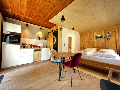 Schlafzimmer mit einem Bett, einem Tisch und Stühlen in der Unterkunft Mallnbach Apartments in Mallnitz