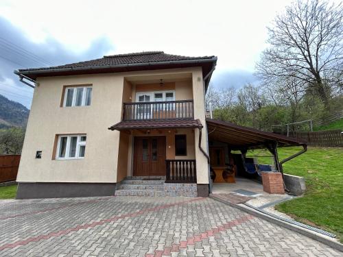 a small house with a balcony and a driveway at Casa Vidra in Vidra