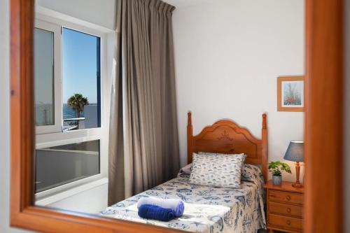 - une chambre avec un lit et une grande fenêtre dans l'établissement Callao Beach 10, à Arrieta