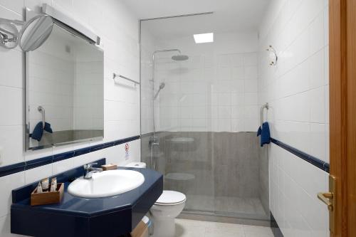 La salle de bains est pourvue d'un lavabo, d'une douche et de toilettes. dans l'établissement Callao Beach 10, à Arrieta