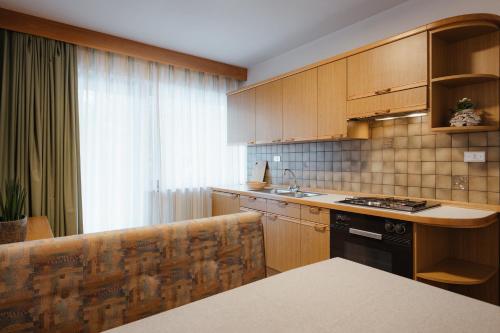 a kitchen with wooden cabinets and a counter top at Residence Arche Noah - Colfosco in Colfosco