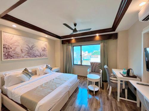 a bedroom with a large bed and a desk and a table at Skon Boutique by Orion Hotels in New Delhi