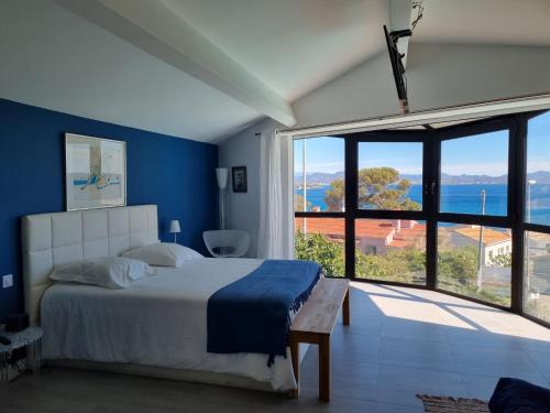 a bedroom with a bed and a large window at Malouins 2307 villa in Les Issambres