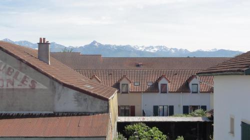 un groupe de bâtiments avec des montagnes en arrière-plan dans l'établissement Petit cocon Tarbais -wifi-parking, à Tarbes