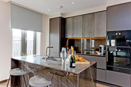 a kitchen with a counter with bottles of wine at 37GS Residences in London